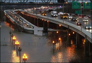 The Ohio River floods under the Third Street exit ramp from I-64 in downtown Louisville, Ky., during rush hour Thursday.