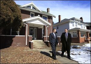 David Mann, director of the Lucas County land bank, left, and county Treasurer Wade Kapszukiewicz leave a property at 1044 Lincoln Ave., a three-bedroom house that they say needs extensive work.  
