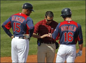 Cleveland's Jason Donald, right, is examined by trainer Lonnie Soleff after getting hit by a pitch on March 5 as Sandy Alomar, Jr., looks on. Donald has a small crack in the base of the long finger of his left hand and won't be ready for the Indian's season opener.