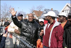 Bill Cosby waves to people on their porches as he walks down Woodland Drive in central Toledo. The comic used wit to lighten his words on keeping the streets safe for children and the elderly. 