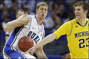 Duke forward Mason Plumlee loses the ball as Michigan forward Evan Smotrycz (23) knocks it away.