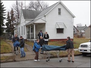 Two of the four bodies found dead from apparent carbon monoxide poisoning are removed Wednesday from 1319 Hamilton Street in Toledo.