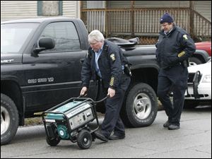 Toledo Police take possession of a portable generator at 1319 Hamilton St. in central Toledo where a mother and three children were found dead in the living room.