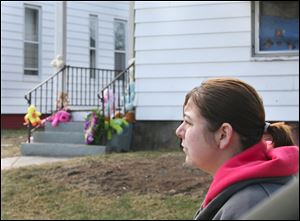 Aubrey Ibarra stops at the memorial set up on the steps of 1319 Hamilton St., where four bodies were found together in the living room. The house had no central heat, and the family was using a gas-powered generator.