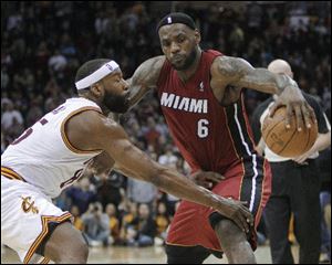 Cleveland Cavaliers' Baron Davis, left, defends Miami Heat's LeBron James (6) in the fourth quarter. The Cavaliers won 102-90.