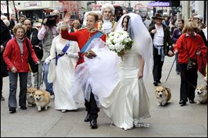 Impersonators Simon Watkinson as Prince William and Jodie Bredo as Kate Middleton walk through the streets of London in wedding attire to promote photographer Alison Jackson's new book 