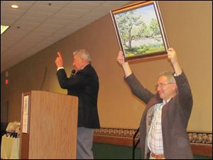 Tom Sorrell, the club's president and Best of Show ribbon winner, displays a piece for bidding.