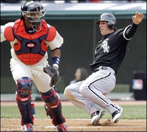 Chicago's Brent Morel, right, scores on a single by Juan Pierre as Indians catcher Carlos Santana waits for the ball in the sixth inning.