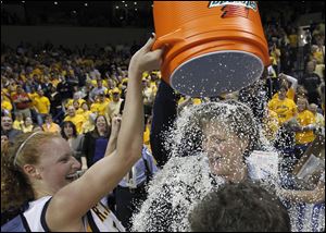 Player Melissa Goodall dumps confetti on coach Tricia Cullop as they celebrate UT's Women's National Invitation Tournament win, the first postseason tournament championship in the school's history.