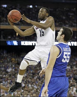 Connecticut's Kemba Walker shoots as Kentucky's Josh Harrellson defends during the second half.