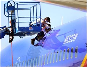 A member of the National Transportation and Safety Board investigating the emergency landing of Southwest Airlines flight 812 cuts away a portion of the planes fuselage on Sunday in Yuma, Ariz.  