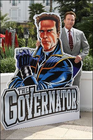Arnold Schwarzenegger poses with artwork from 'The Governator'.