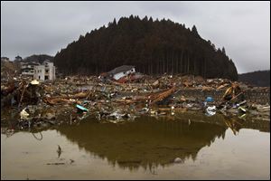 Ruins of a neighborhood in Minamisanriku, a town in northeast Japan, surround a pool of seawater. Of the 17,666 people who once lived there, 300 have been confirmed dead; thousands more are missing.