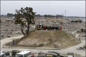 Buddhist monks, Japan Self-Defense Force personnel firefighters and other relief workers observe a moment of silence at 2:46 p.m. on Monday, exactly one month after the devastating earthquake hit northeastern Japan, on 