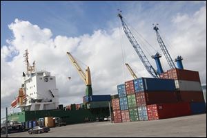 Shipping containers stacked next to the cargo ship Westerhaven at the Port of Miami are one indicator of U.S. imports and exports.