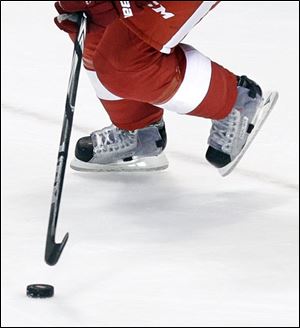 Red Wings defenseman Niklas Kronwall controls the puck during the third period in Game 1 of a first-round NHL hockey playoff series against the Phoenix Coyotes. Kronwall, Drew Miller, Darren Helm, Brad Stuart, and Patrick Eaves use Skate Fenders on their skates to protect the top and sides of their feet during shot blocking.