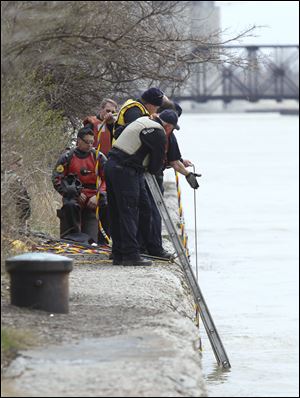Toledo firefighters tend to a diver in the water while another sits ready as they search the Maumee River for evidence just downstream from the Willis B. Boyer Museum Ship in East Toledo. Divers found nothing and will resume the search, but not Saturday because of high winds in the forecast, Fire Chief Mike Wolever said.