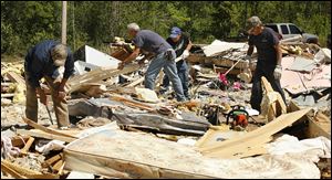 Friends and family try to salvage belongings from the rubble of the Box family's mobile home in Deer Park, Ala. Three family members were killed in Friday night's storm.