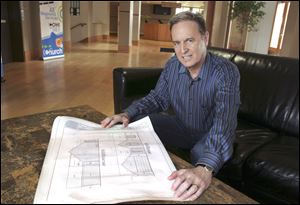 Pastor Tony Scott displays some of the architectural drawings of the house that the Church on Strayer in Maumee will give to a family. 