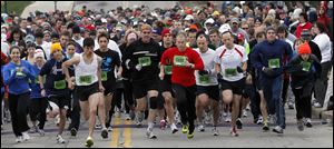 The 5K runners take off at the start of the Glass City Marathon. Louis Pablo Guardiola, left #5612, from Fremont, came in first place.