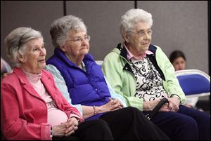 Marion Wright, Jeanne Quinlivan, and Rose Williams, from left, watch students perform Right-to-Read Week entertainment at St. Rose School.