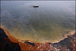 A shrimp boat uses booms to collect oil in the waters of Chandeleur Sound, La., in this May 5, 2010 file picture/ An April 20, 2010, explosion at the BP Deepwater Horizon offshore platform killed 11 men, and the subsequent leak released an estimated 172 million gallons of petroleum into the Gulf of Mexico.