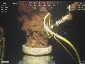 In this July 12, 2010, image from video made available by BP PLC, oil flows out of the top of the transition spool, which was placed into the gushing wellhead and will house the new containment cap, at the site of the Deepwater Horizon oil spill in the Gulf of Mexico. 