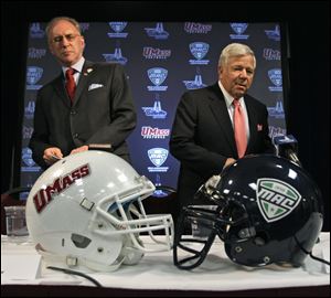 Massachussets chancellor Robert Holub, left, talks with New England Patriots owner Robert Kraft at Gillette Stadium, where the Minutemen will play their home games.