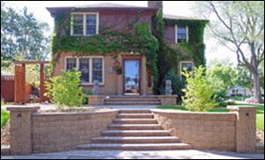 A front-entry makeover adds classy curb appeal
to this Wisconsin home. The tan retaining walls
and columns are a perfect match for the home's
exterior stonework.
