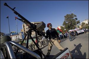 A Libyan rebel fighter leads a rally against Libyan leader Muammar Gaddafi in Benghazi, Libya, Saturday.