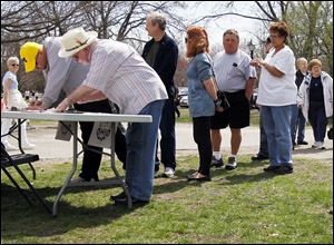 David Werner, wearing the white hat, adds his name to We Are Ohio’s petition to put a referendum on the November ballot to repeal Senate Bill 5. Numerous petition drives were held across Ohio on Saturday.