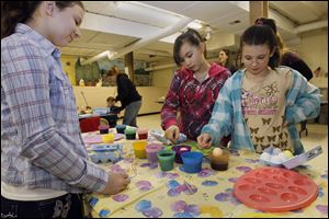 From left, Erin Patterson, 12, Ashleigh Inocentes, 11, and Christina Patterson, 10, all of Toledo, dye eggs.