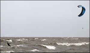 Ryan Owens of Toledo uses the wind blowing across Lake Erie at Luna Pier to his advantage, harnessing the gusts so he can ride the waves on his kite board.