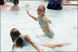 Madison Theis, right, splashes around the water with friend Kelsey Reece, left, while spending the afternoon at Pickford Pool last July.