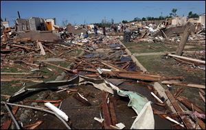 A road into the Rosedale Court housing community in Tuscaloosa, Ala., is covered by debris from Wednesday's tornado. President Barack Obama is in Alabama Friday to view damage and meet with the governor and families.