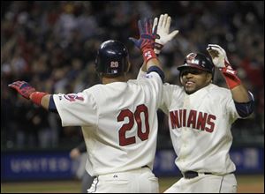 Cleveland's Carlos Santana, right, runs to congratulate Orlando Cabrera (20) after Cabrera's bases loaded single in the 13th inning gave the Indians a 3-2 win over the Detroit Tigers on Saturday.