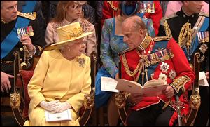 In this image taken from video, Queen Elizabeth II speaks with Prince Philip at Westminster Abbey for their grandson’s wedding.