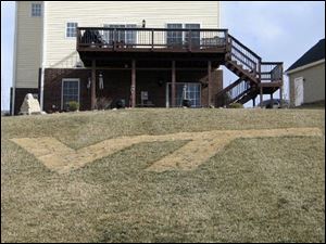 The Virginia Tech logo is landscaped into the lawn of fan Mike Goatley, as the homeowner shows his pride in Blacksburg, Va.