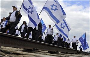 Participants of the traditional 'March of the Living' walk behind a railway track inside the former Auschwitz-Birkenau Nazi Death Camp near Oswiecim, southern Poland Monday.