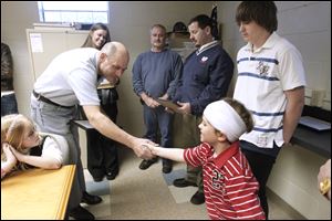 Jack Foster, left, shakes hands with 9-year-old Tye Warwick, right, of Green Springs, who was struck by a minivan and dragged about 90 feet before the vehicle stopped. Also present are, from left, Amanda Spencer, Duane Spencer, Steve Spencer, and Dylan Warwick who stand nearby after receiving a certificate of recognition for helping Tye.