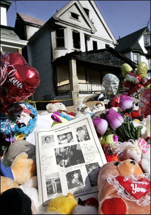 Pictures of the fire victims rest on stuffed animals in front of the burned-out house in Cleveland where nine people died, in this June 1, 2005 file photo.