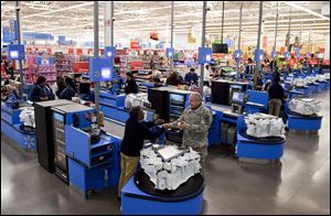 Customers check out at a Wal-Mart store in Alexandria, Va.