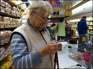 In a Giant supermarket, Vicenza Cerrato scans a receipt for items bought at a superdiscount store nearby. She is part of a growing trend in the post-recession economy.