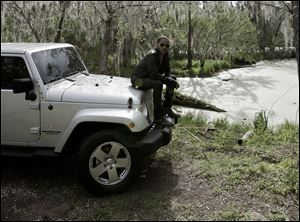 Rock star Lenny Kravitz sits on the hood of the silver 2011 Wrangler Sahara Unlimited that was rented from the Monroe Dodge Superstore for a series of new Jeep commercials. 