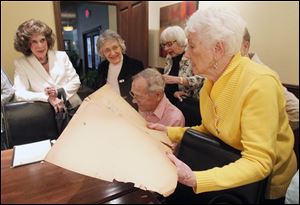 Joyce Dennison holds a scrapbook as she joins class of 1944 members Kleo Boyles, left, Madelyn Botek, Bob Nusbaum, and JoAnn McCloskey at their most recent luncheon. 