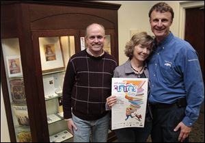 From left, David Justus and Julie and David Rubini in front of the Maumee Library display honoring
Claire Rubini, who had a heart problem and died in 2000. A year later, the Rubinis developed a reading
program for kids called Claire’s Day.