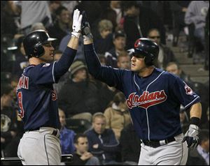 Cleveland Indians' Jack Hannahan, left, greets Matt LaPorta at home plate after LaPorta's home run off Chicago White Sox relief pitcher Tony Pena during the ninth.
