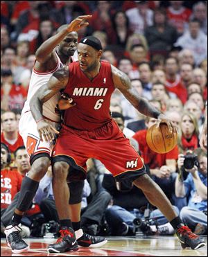 Miami's LeBron James drives against Chicago's Luol Deng Wednesday night in Game 2 of the Eastern Conference finals. The Heat won 85-75 to tie the series heading back to Miami for Game 3.