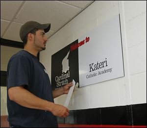 J. Dianda of Toledo putting up the new logos for the schools.