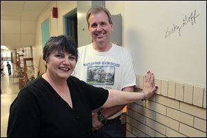 Maplewood Elementary teacher Becky Goff stands with Principal Ed Eding after she signed a school wall. Mr. Eding, who said he felt bittersweet about replacing the building with a new one, had taught sixth grade there.